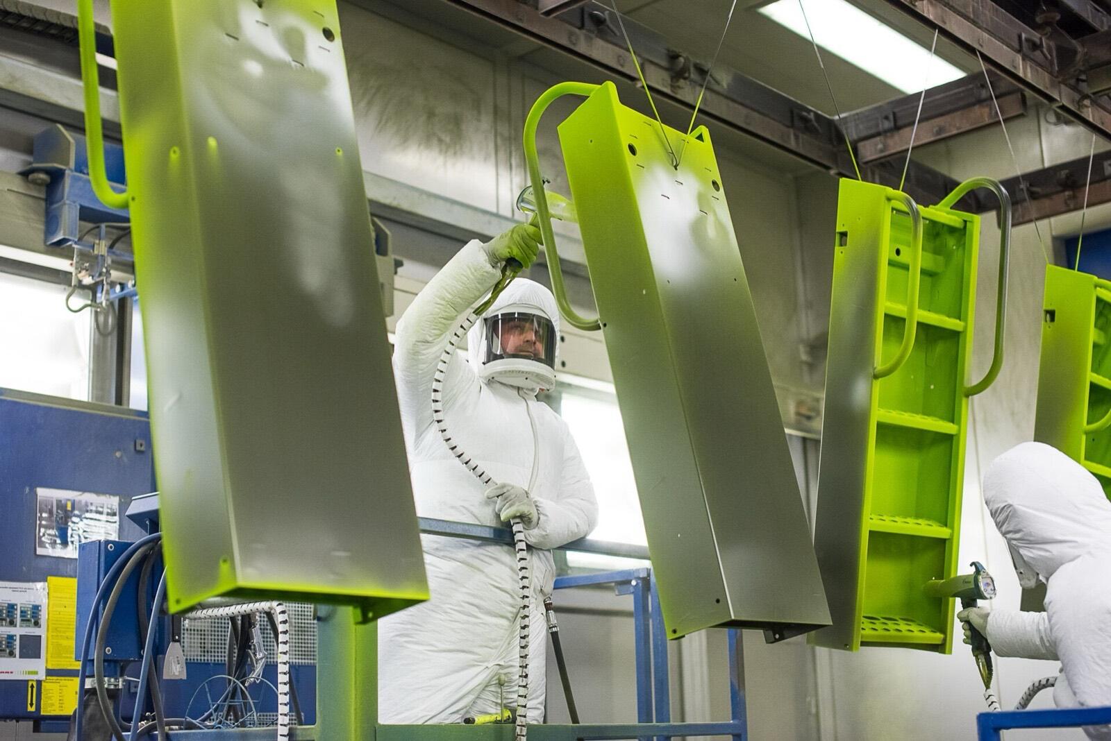 Powder-coating booth with parts hung for spraying